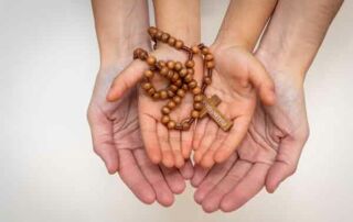 two hands with rosary